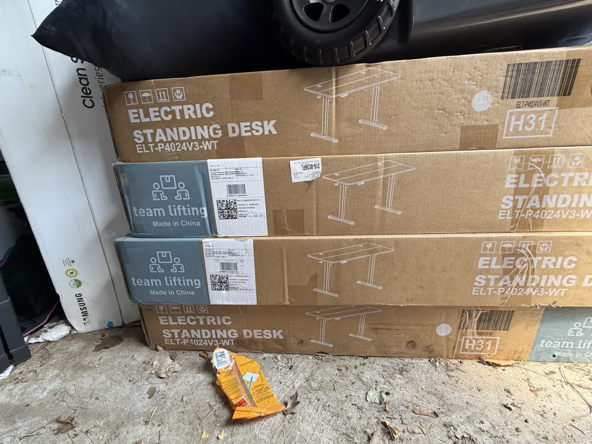 Four Electric Standing Desk cartons, model ELT-P4024V3-WT, showing warehouse handling wear