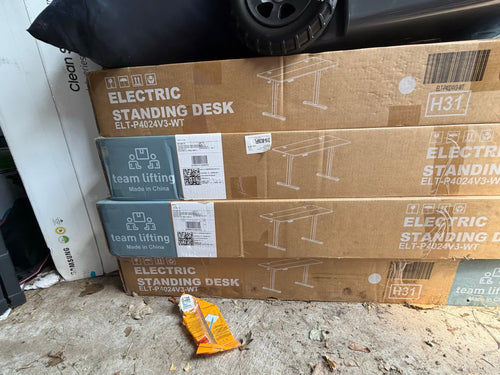 Four Electric Standing Desk cartons, model ELT-P4024V3-WT, showing warehouse handling wear