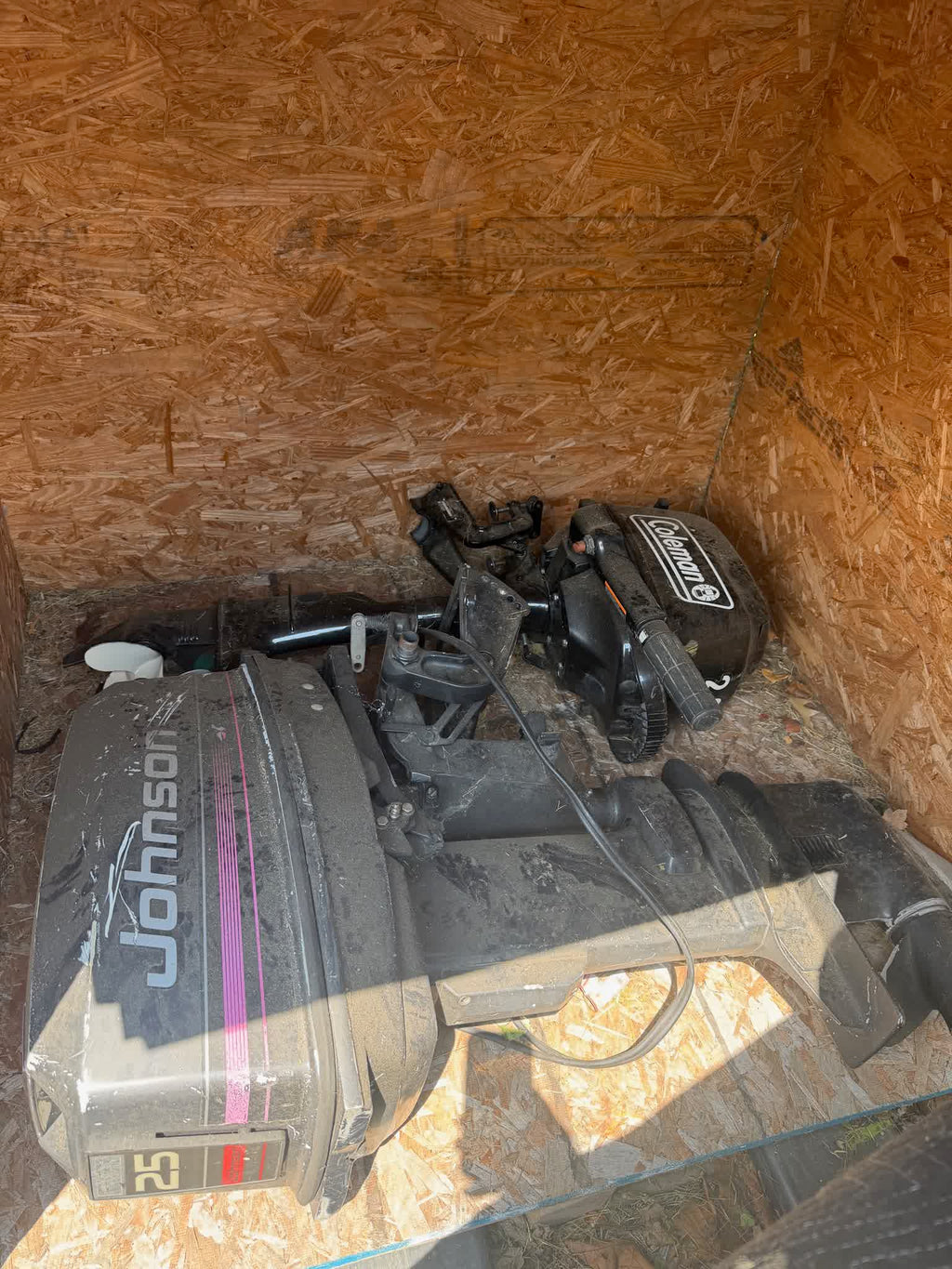 Johnson 25 HP outboard in storage, side view with second motor behind