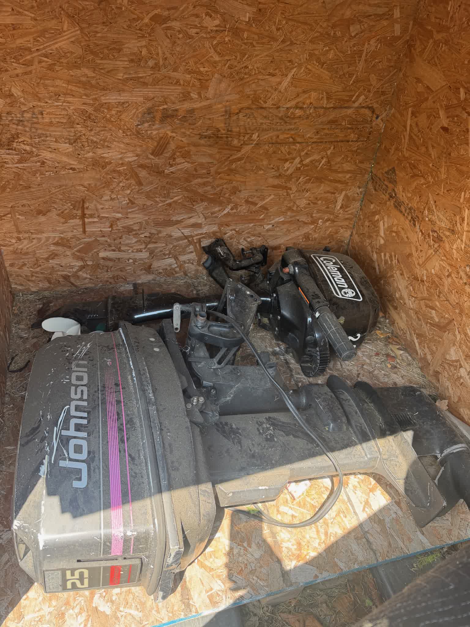 Johnson 25 HP outboard in storage, side view with second motor behind