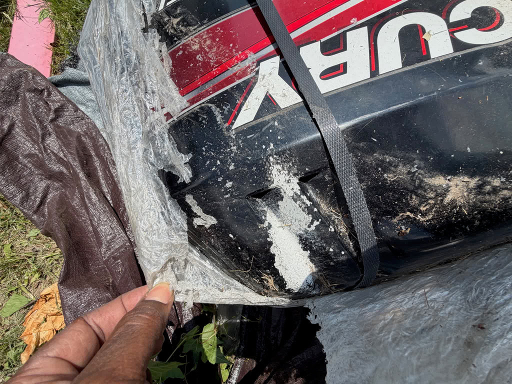 Close-up of cracked rear cowl corner damage on Mercury outboard