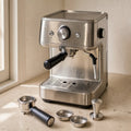 Pre-owned stainless compact espresso machine with portafilter, baskets, and tamper