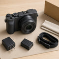 Pre-owned compact mirrorless camera with battery, charger, and strap